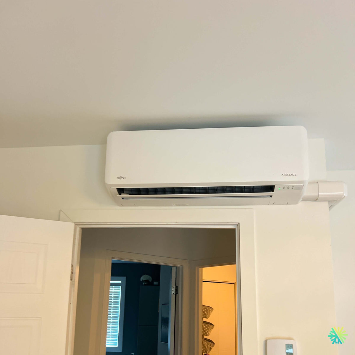 Installation d’une thermopompe murale Fujitsu AIRSTAGE Orion XLTH à Sainte-Marthe : une intégration compacte au-dessus d’une porte pour un confort quatre saisons