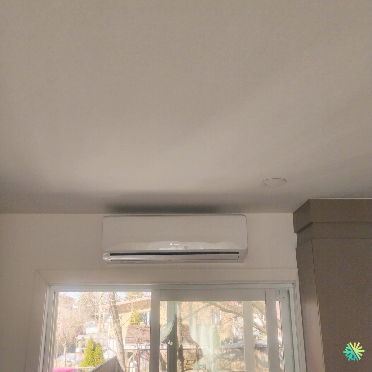 Installation d’une thermopompe murale GREE CHARMO R32 à Dorval : un climatiseur mini split installé au-dessus d’une grande porte-patio pour un confort précis et discret