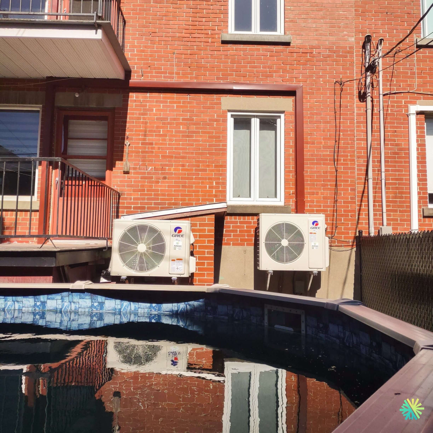 Installation d’une thermopompe murale GREE CLIVIA R32 à Boucherville : deux unités mini split installées avec précision dans une cour arrière résidentielle avec piscine