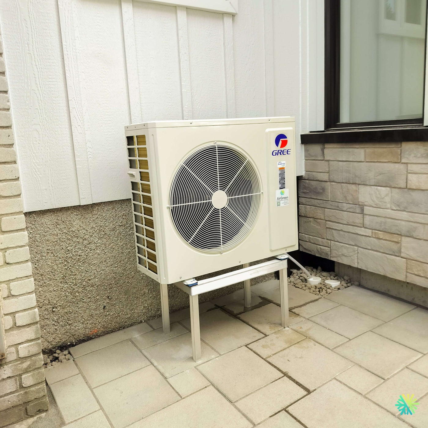 Installation d’une thermopompe murale GREE CROSSOVER R32 à Anjou : climatiseur mini split installé proprement dans une cour résidentielle