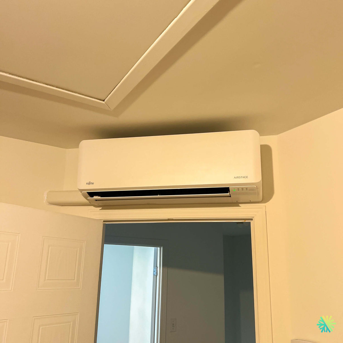Installation d’une thermopompe murale Fujitsu AIRSTAGE Altair 700 à Huntingdon : une installation compacte et précise au-dessus d’une porte