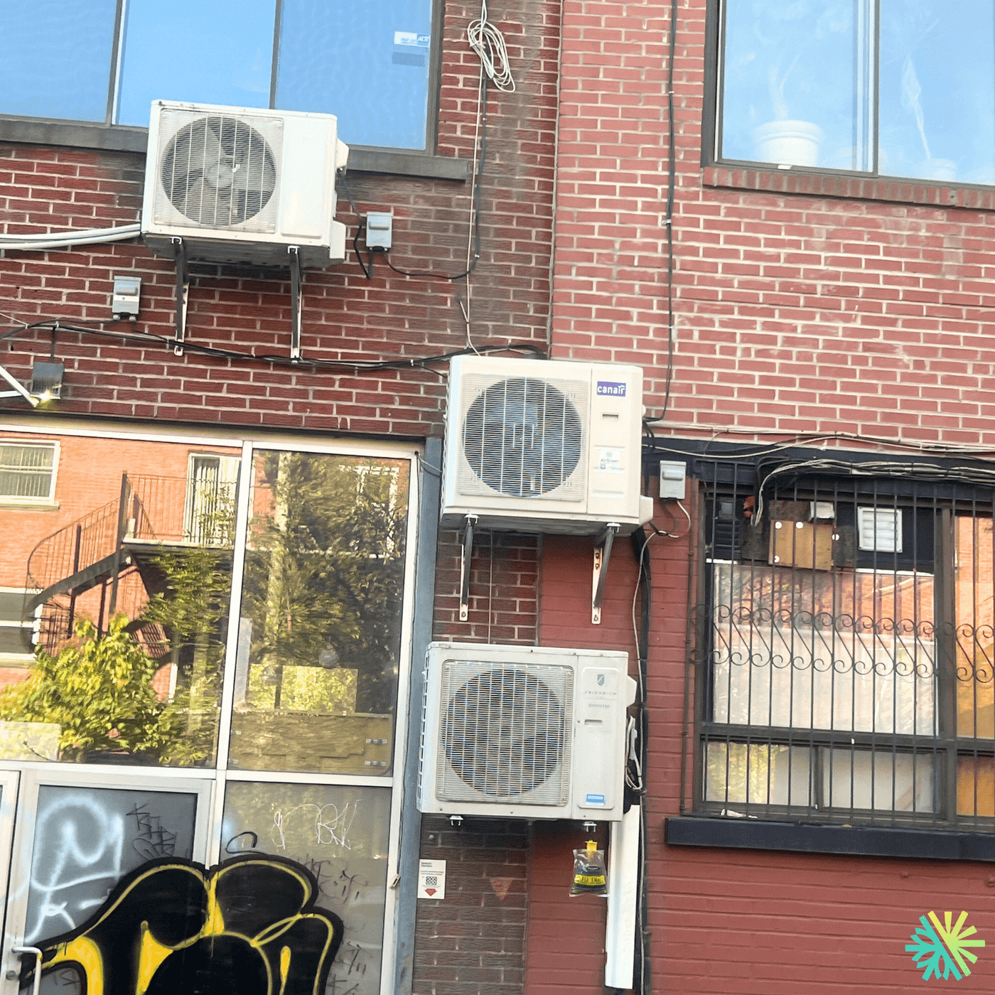 Installation d’une thermopompe murale Canair sur immeuble en brique au Plateau-Mont-Royal