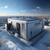Modern commercial heating unit on a rooftop with a city skyline, illustrating how to maintain heating between service visits in winter conditions.