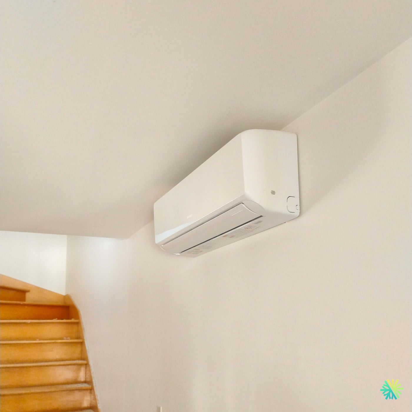 Installation d’une thermopompe murale GREE LIVO R32 à Beaconsfield : climatiseur mini split mural installé près d’un escalier par AirGreen