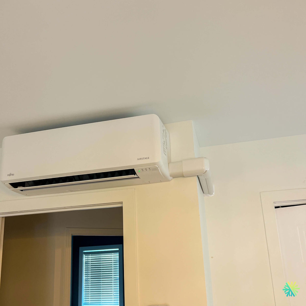 Installation d’une thermopompe murale Fujitsu AIRSTAGE Altair 700 à Saint-Rémi : une intégration propre et compacte au-dessus d’une porte intérieure