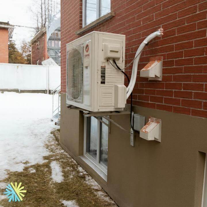 Technicien installant une thermopompe murale, guide "Comment installer une thermopompe murale?" pour chauffage efficace à Montréal.