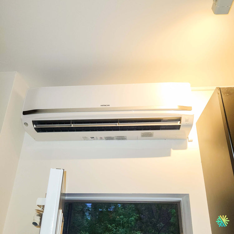 Installation d’une thermopompe murale Hitachi airHome 800 au-dessus d’une fenêtre à Anjou, Montréal