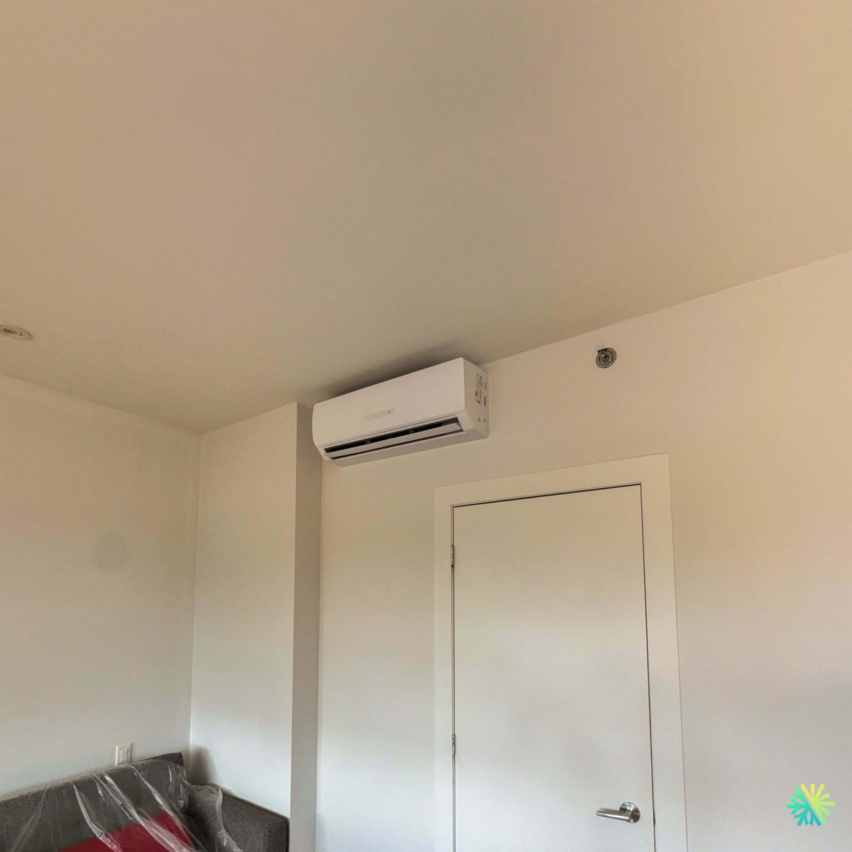 Installation d’une thermopompe murale GREE CROSSOVER R32 à Saint-Vincent-de-Paul, Laval : un mini split discret installé au-dessus d’une porte intérieure pour un confort ciblé