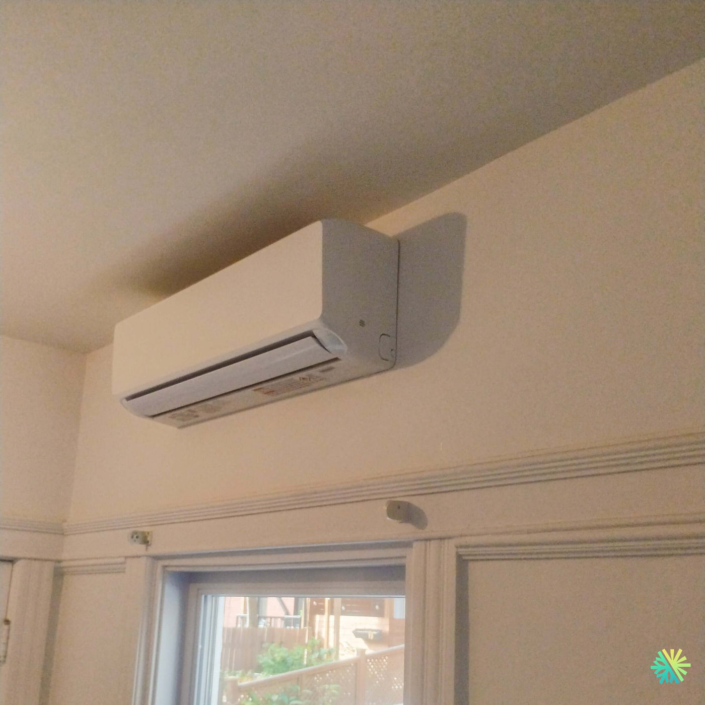 Installation d’une thermopompe murale GREE LIVO R32 12 000 BTU à Dorval : climatiseur mini split au-dessus d’une fenêtre résidentielle