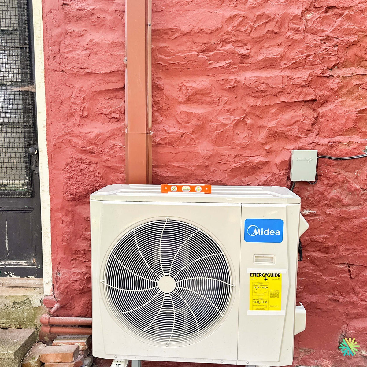 Installation d’une thermopompe murale MIDEA MIDEA28 à Terrasse-Vaudreuil : une unité extérieure mise au niveau avec précision sur une façade de maçonnerie