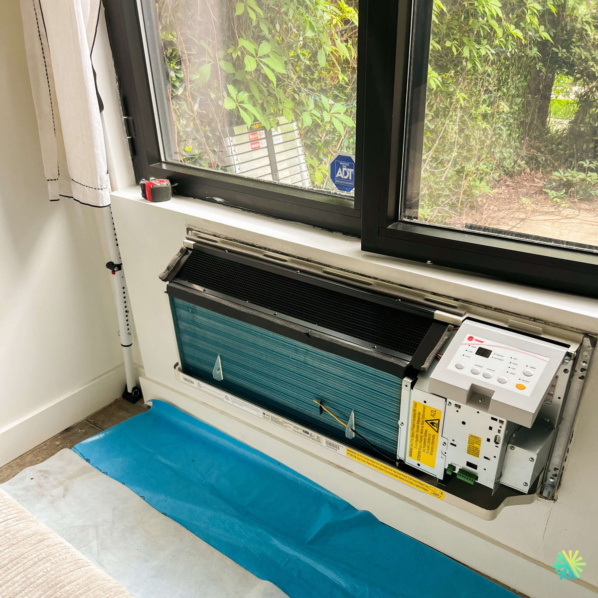 Installation d’un PTAC TRANE PROSPACE sous une fenêtre dans une chambre à Saint-Valérien-de-Milton