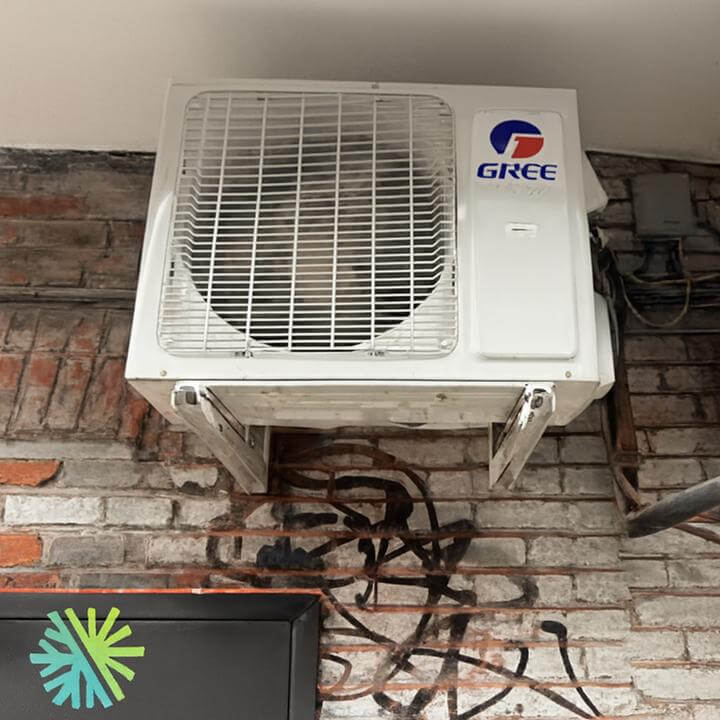 Installation d'une Thermopompe Murale Gree Crossover à Park Extension, Montréal sur un mur de briques.