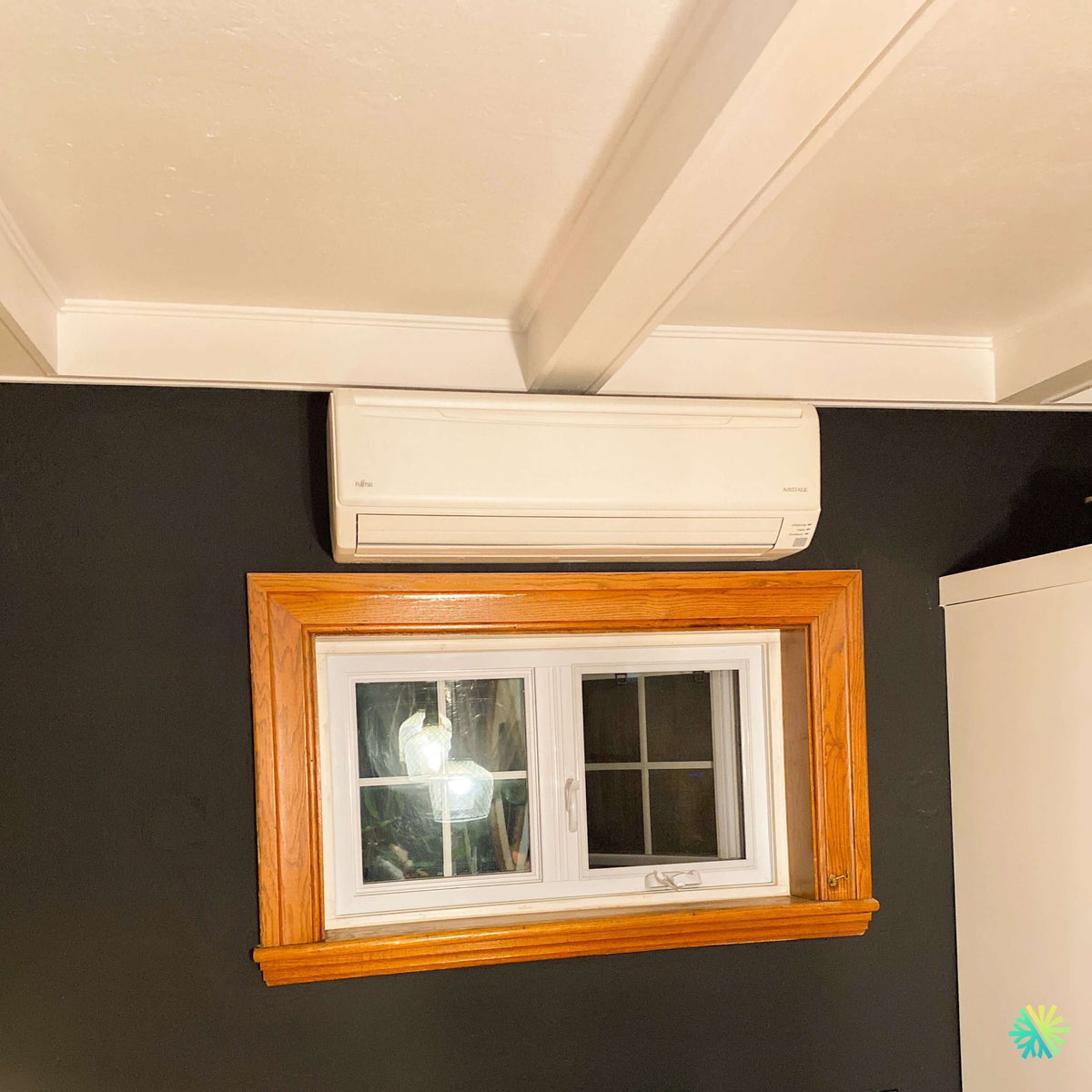 Installation d’une thermopompe murale Fujitsu AIRSTAGE à Ange-Gardien : une intégration précise au-dessus d’une fenêtre dans un espace à dégagement limité