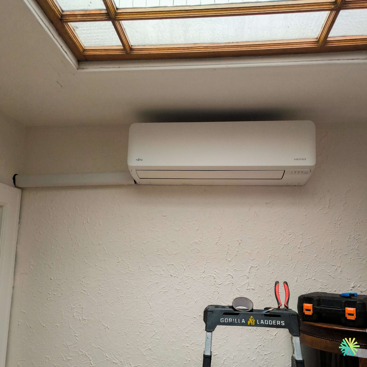 Installation of a Fujitsu AIRSTAGE Altair 700 Wall-Mounted Heat Pump in Très-Saint-Sacrement: Precise Integration Beneath an Indoor Glass Roof
