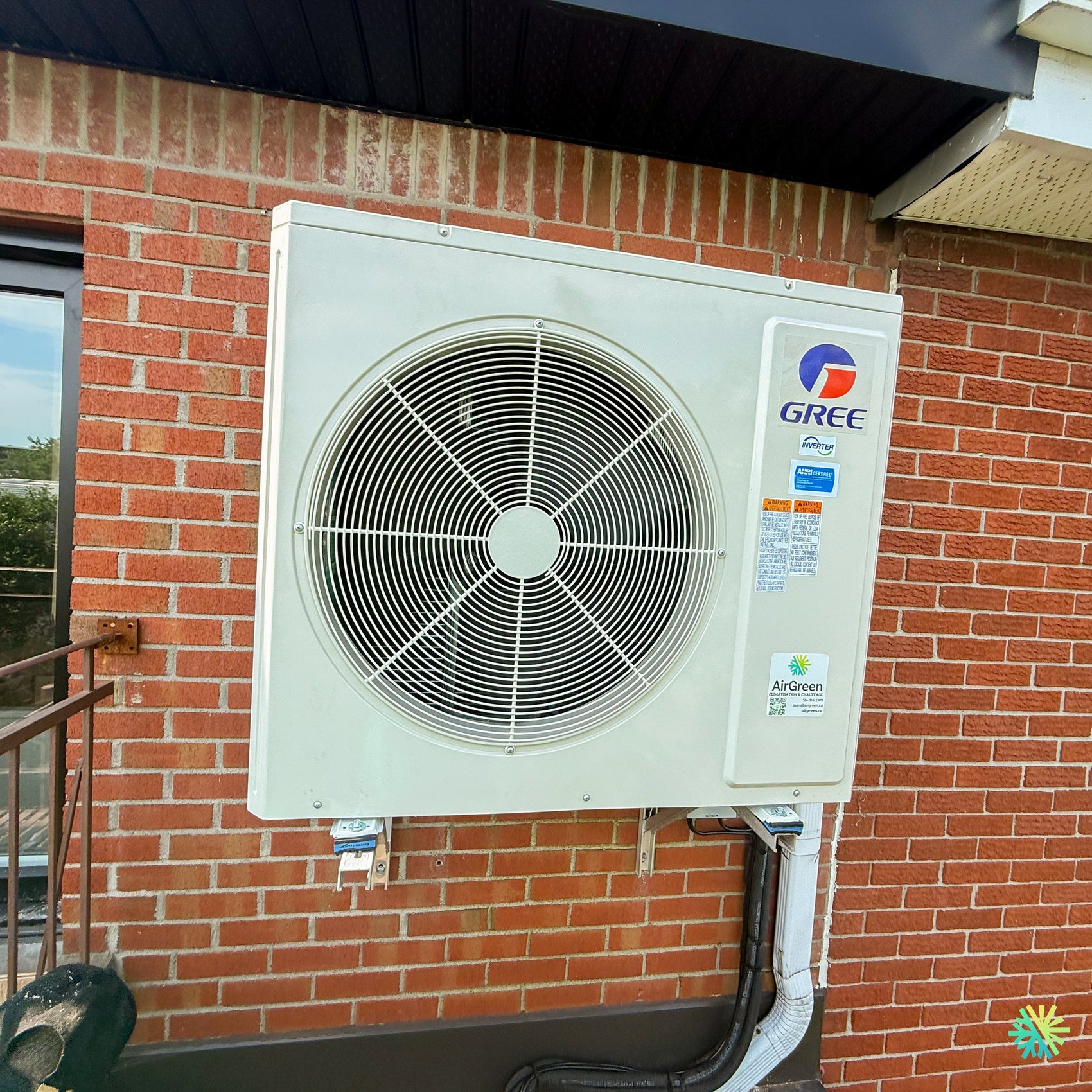 Installation d’une thermopompe 3 têtes GREE FreeMatch R32 à Acton Vale, avec unité extérieure murale sur façade de brique