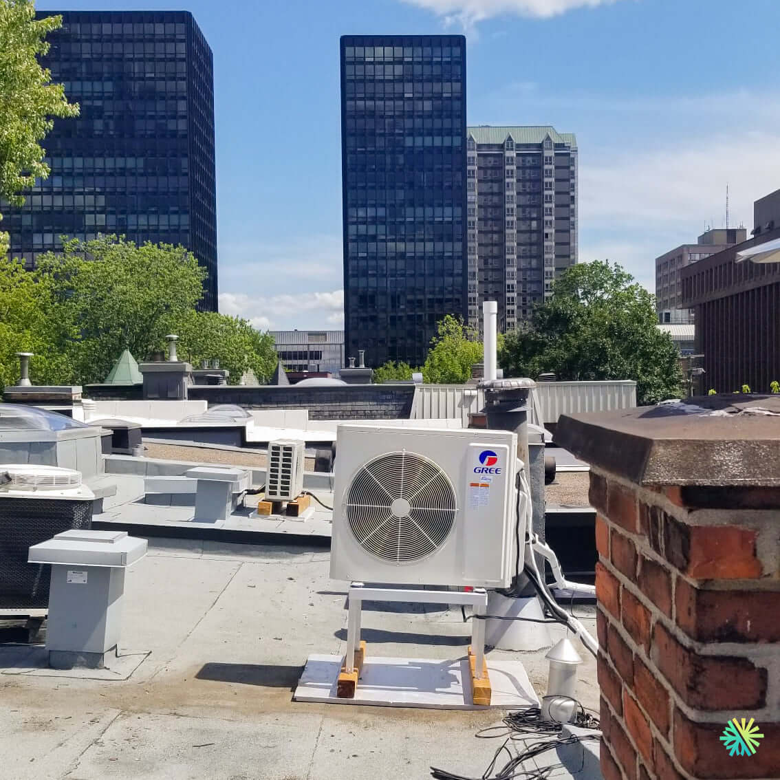 Installation d’une thermopompe murale GREE CHARMO R32 à Montréal-Nord sur un toit commercial avec unité extérieure sur support surélevé