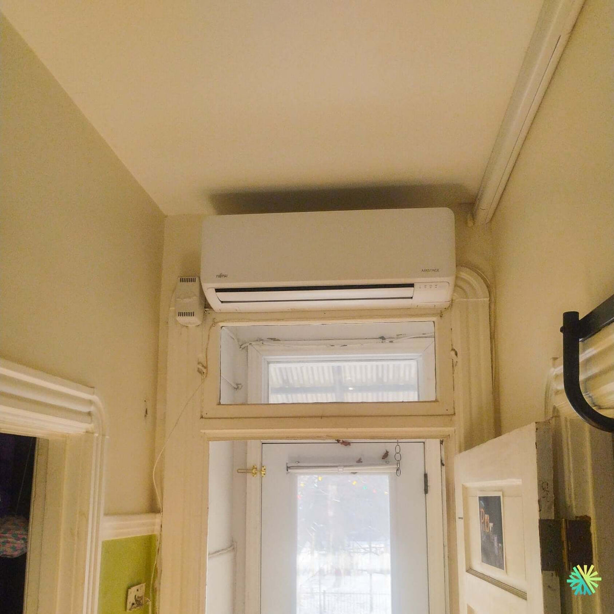 Installation d’une thermopompe murale FUJITSU ALTAIR 700 à Outremont : une solution Mini Split discrète au-dessus d’une entrée vitrée au charme montréalais
