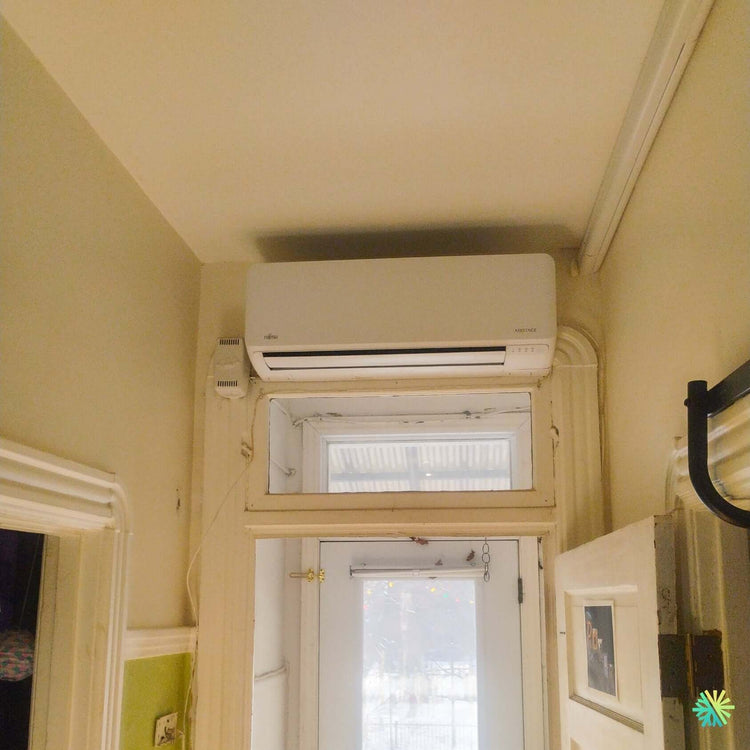 Installation d’une thermopompe murale FUJITSU ALTAIR 700 à Outremont : une solution Mini Split discrète au-dessus d’une entrée vitrée au charme montréalais