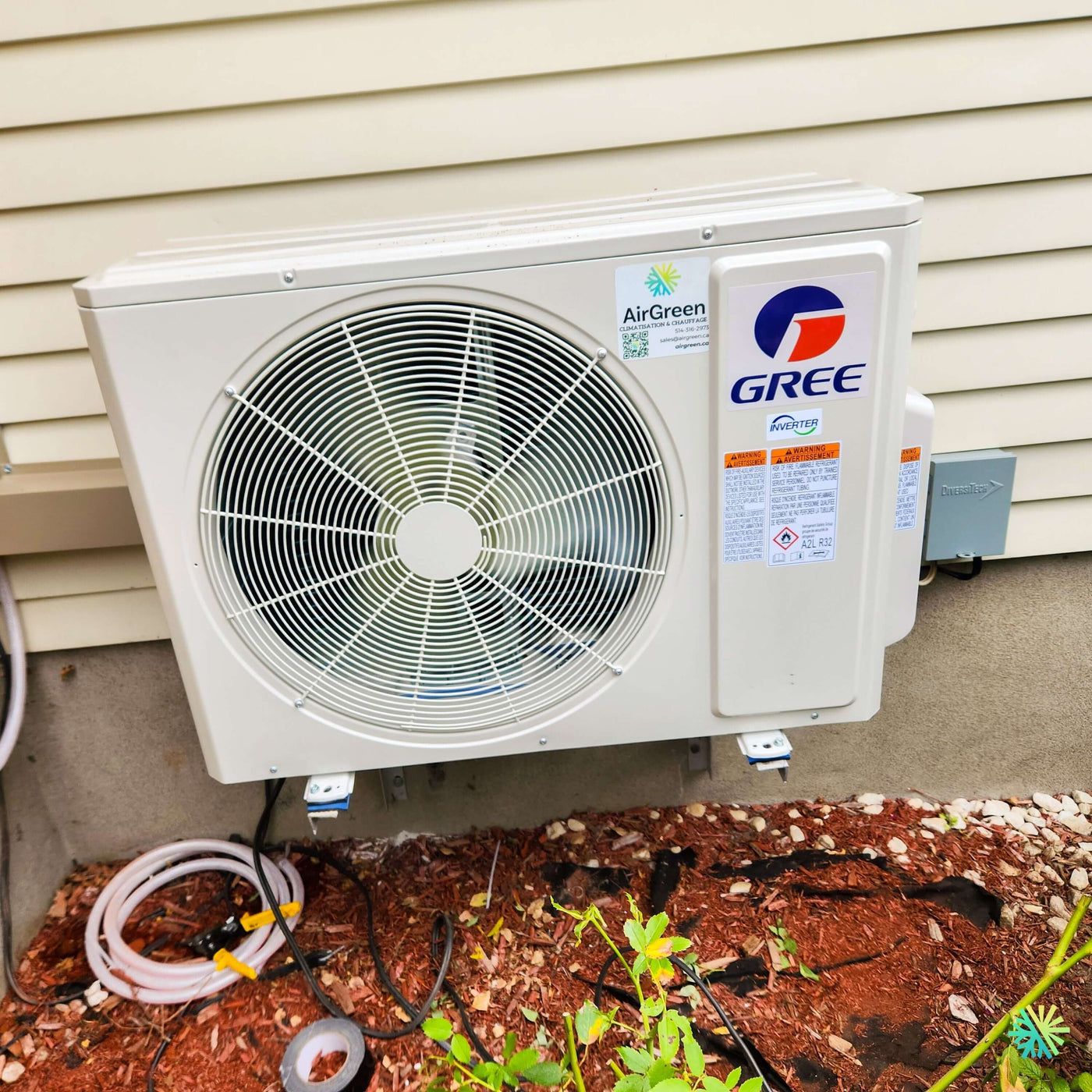 Installation d’une thermopompe murale GREE LIVO R32 Inverter à Montréal-Nord : un mini split résidentiel installé avec précision sur façade extérieure en revêtement horizontal