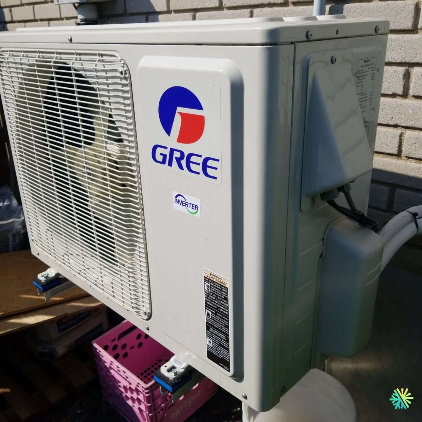 Gree outdoor air conditioning unit installed on a brick wall, showcasing energy-efficient inverter technology.
