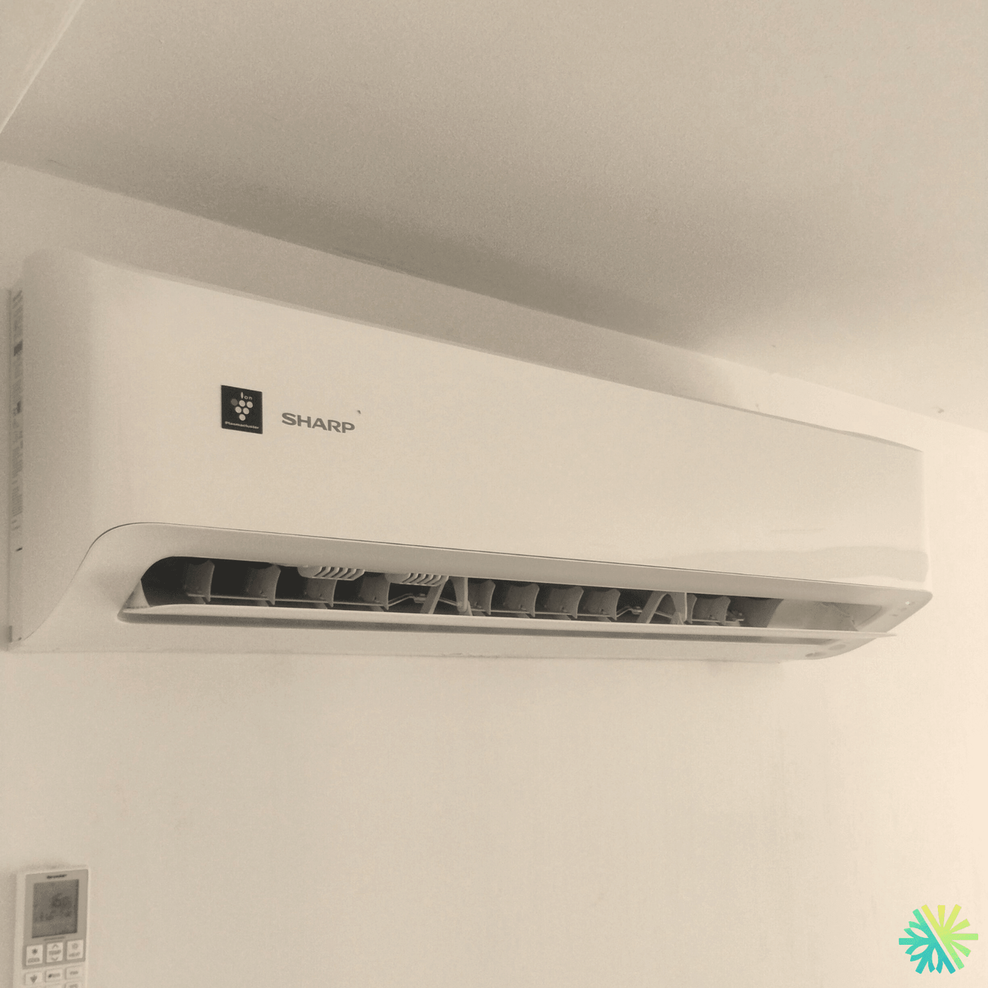 Wall-mounted Sharp air conditioner unit installed in a room, showcasing modern home cooling solutions.