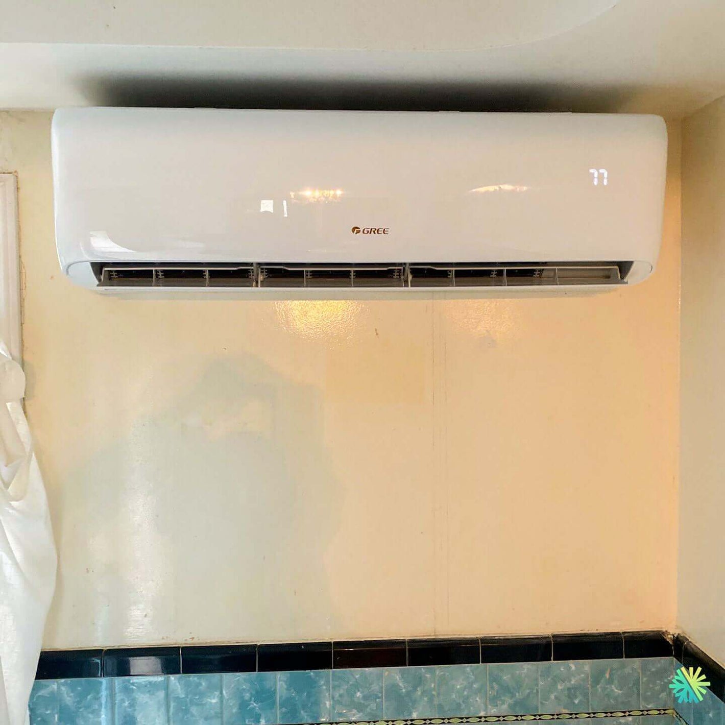 Gree wall-mounted air conditioner installed in a room with blue tiles, operating efficiently