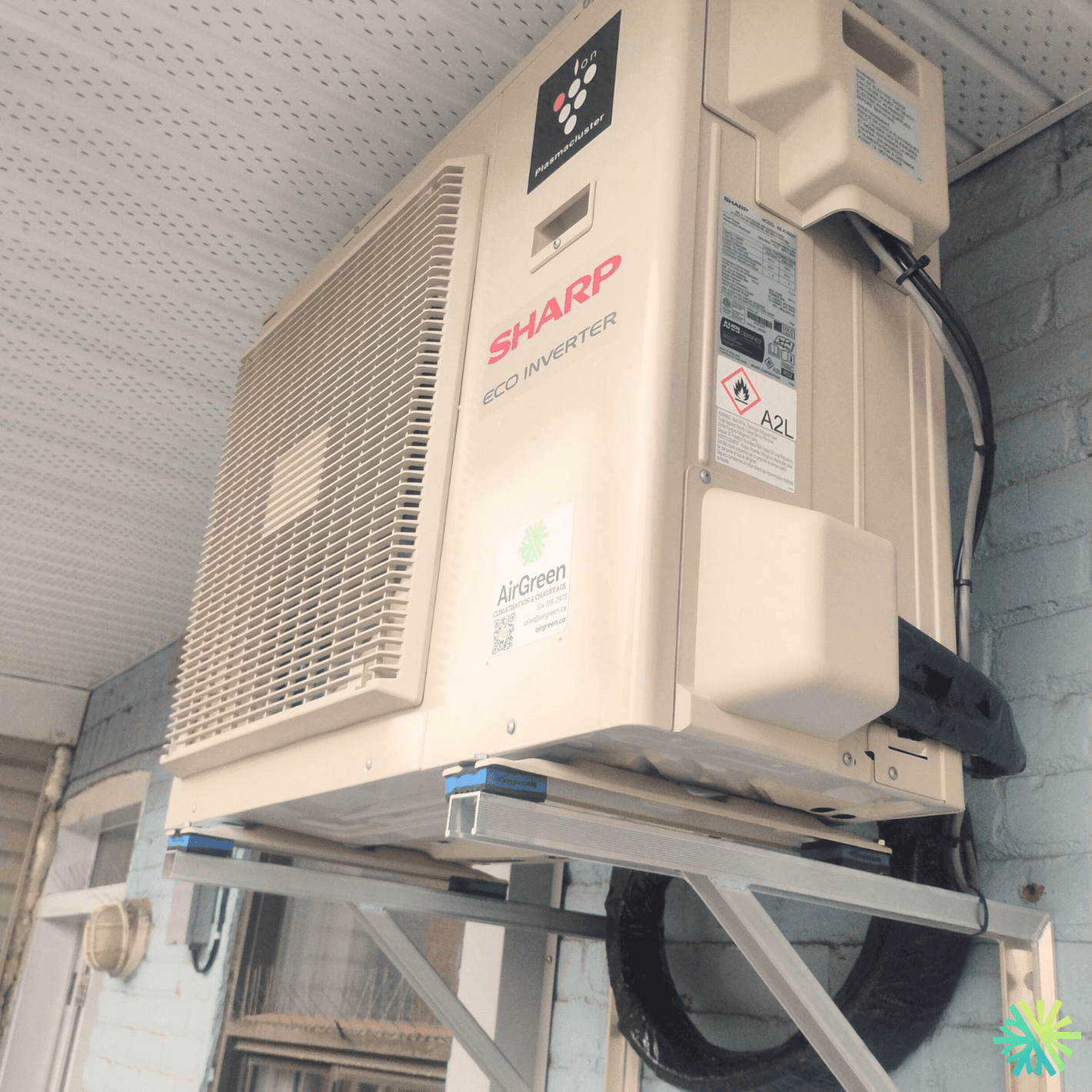 Outdoor view of a Sharp Eco Inverter air conditioner unit mounted on a residential wall.