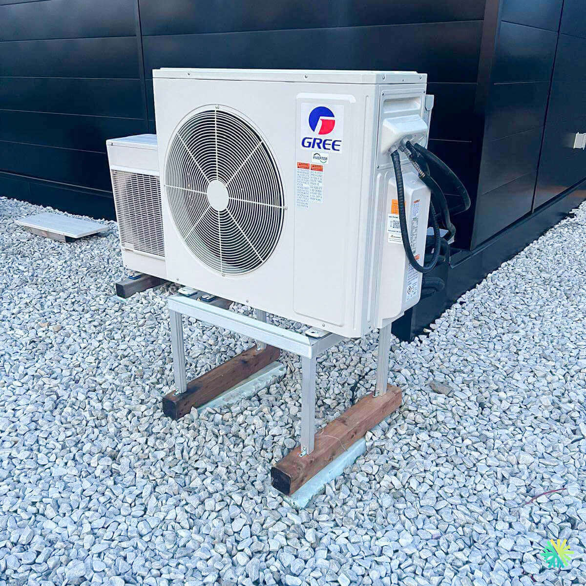 Outdoor Gree HVAC unit installed on a gravel surface, showcasing efficient air conditioning and heating system setup.