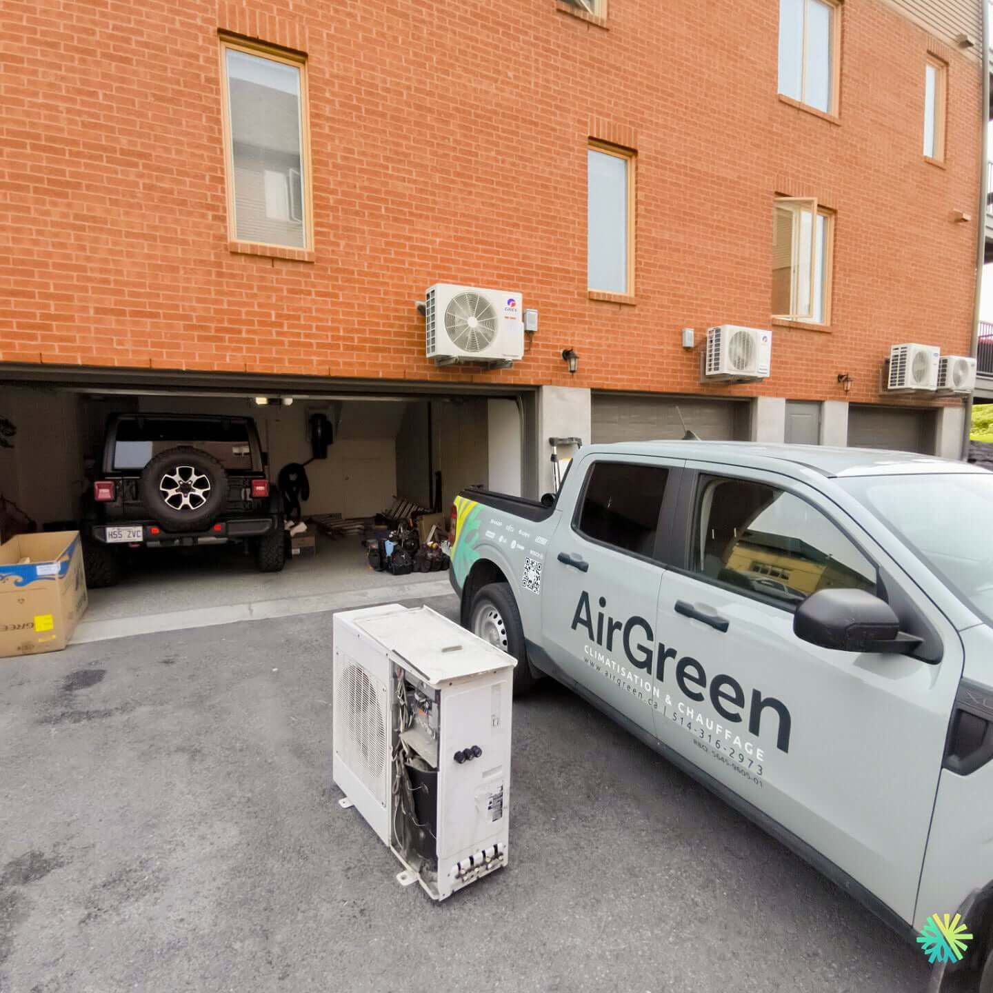 AirGreen service truck parked in front of a brick building with HVAC units and a removed air conditioning unit outside.