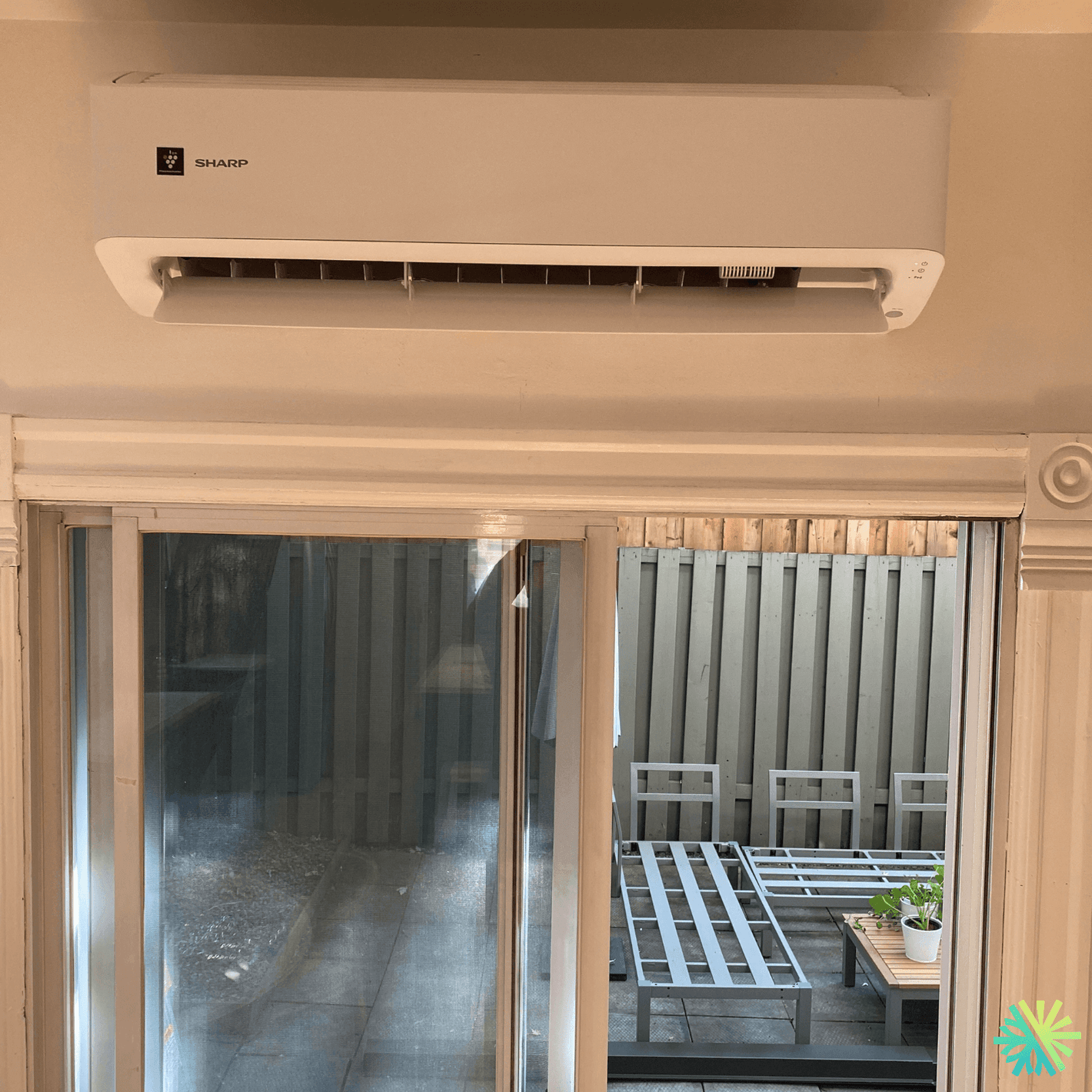 Wall-mounted air conditioner above sliding glass door in modern home interior.