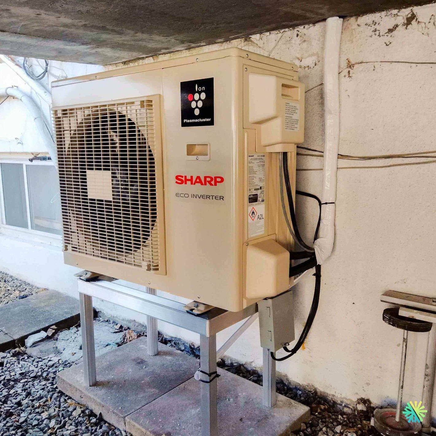 Sharp eco inverter air conditioning unit installed outdoors on a stand, showcasing ion plasma cluster technology.