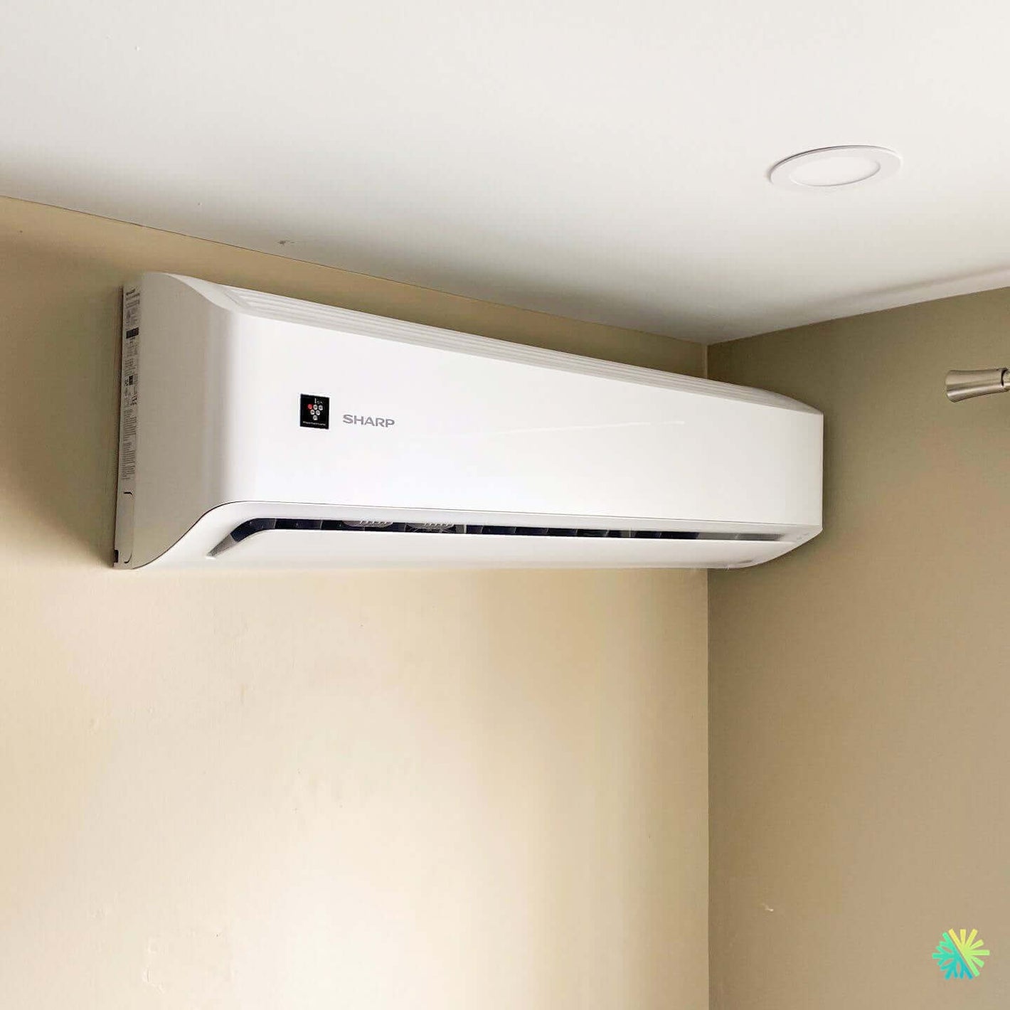 Wall-mounted Sharp air conditioner in a modern room corner, providing efficient cooling.