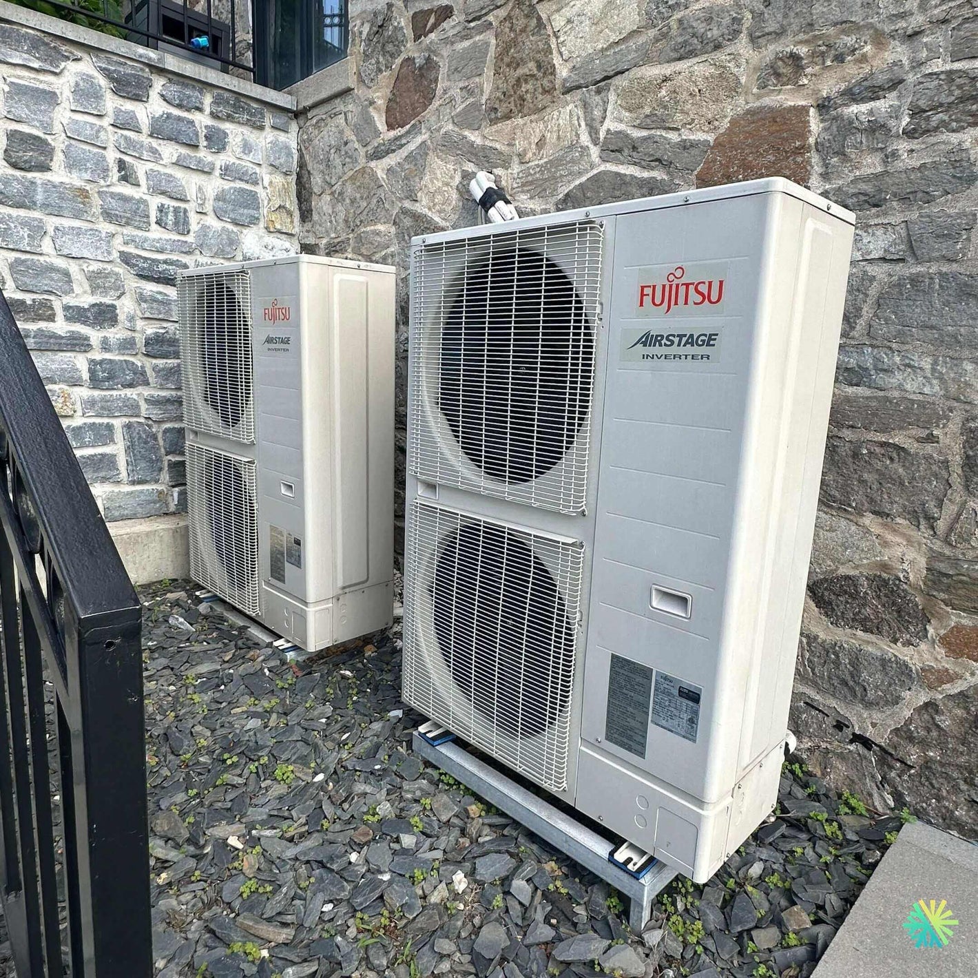 Outdoor Fujitsu Airstage inverter units installed on a stone wall for efficient cooling and heating solutions.