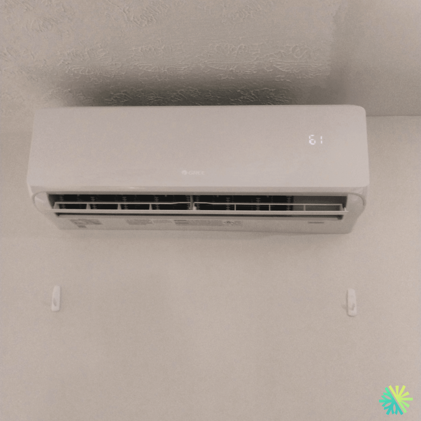 Wall-mounted Gree air conditioner with LED display showing temperature in a modern interior space.