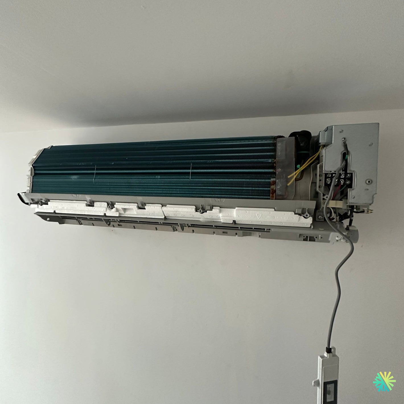Air conditioner unit open for repair and maintenance on the wall.