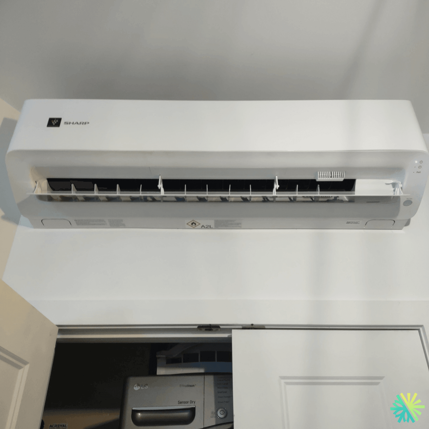 Wall-mounted white air conditioner with open vents in a modern interior setting.