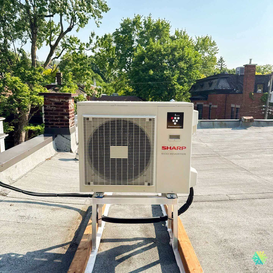 Sharp Eco Inverter AC unit on rooftop with trees in background