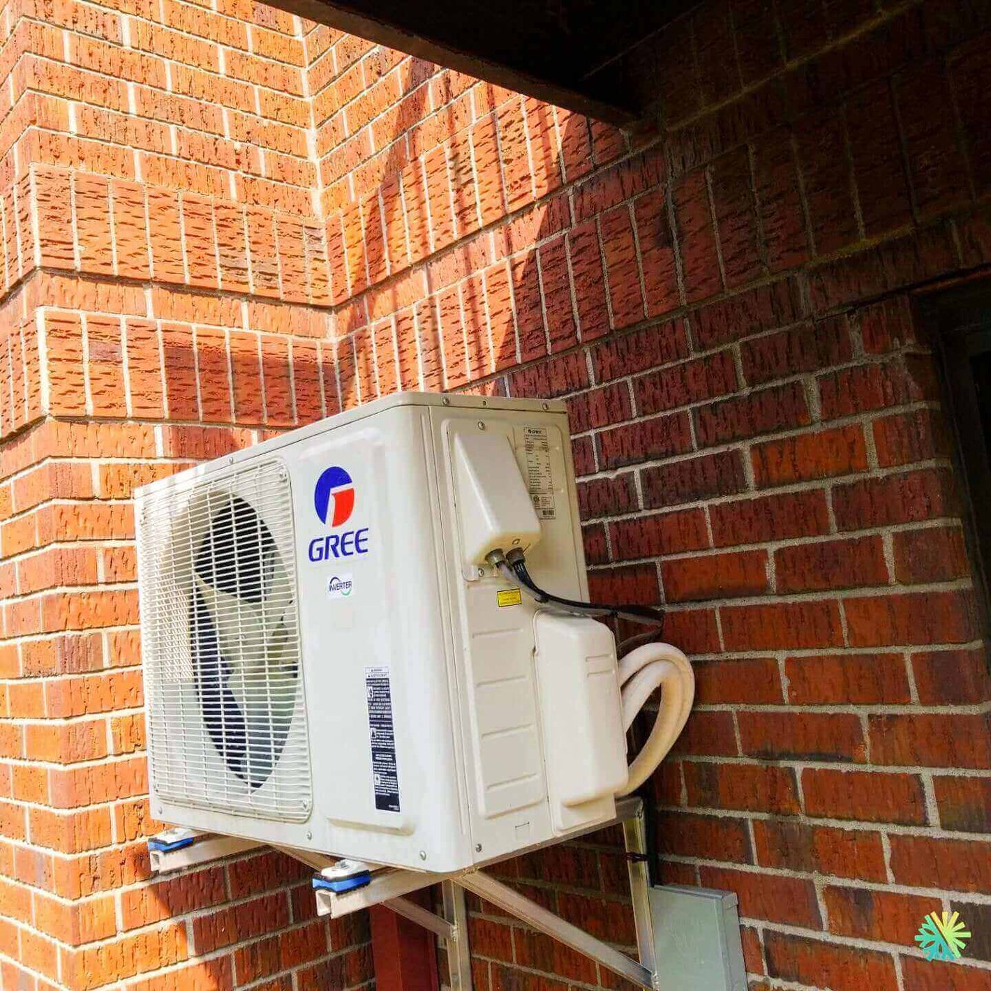 Outdoor Gree air conditioning unit mounted on a brick wall, showcasing efficient exterior installation.