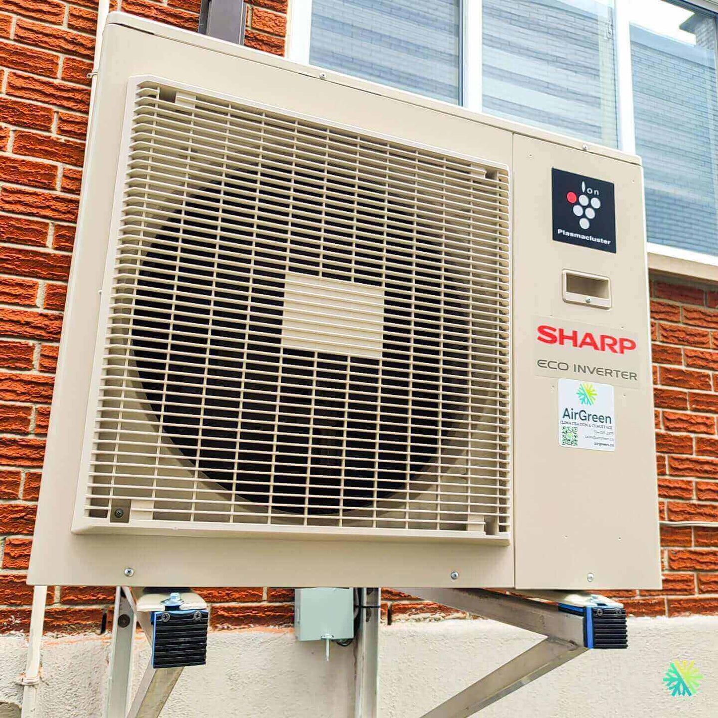 Sharp Eco Inverter air conditioning unit installed on a brick wall exterior.