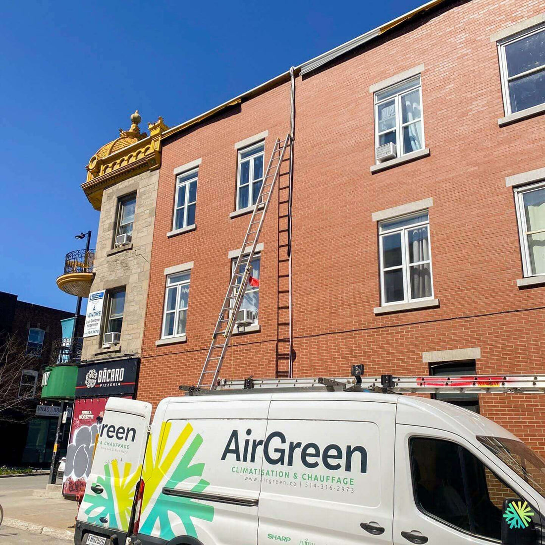 AirGreen service van parked outside brick building with ladder for HVAC installation or repair on a sunny day.