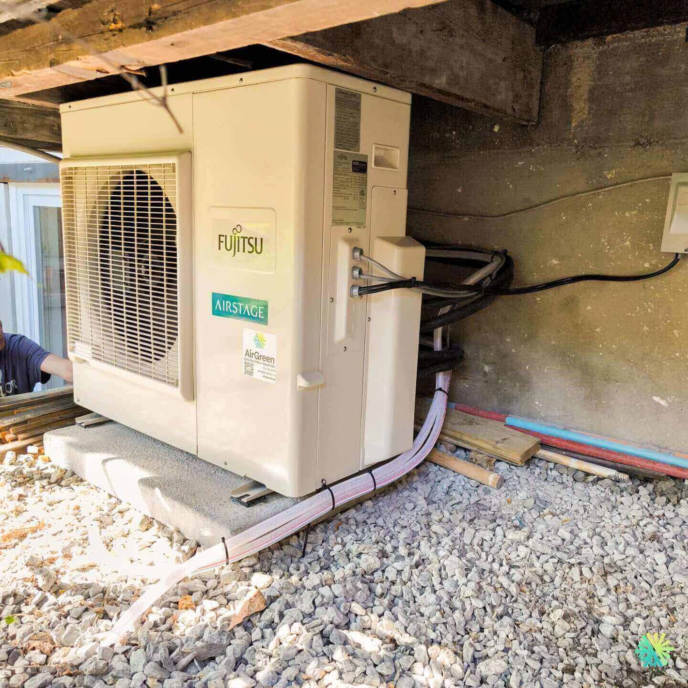 Fujitsu Airstage outdoor HVAC unit installation under a building.