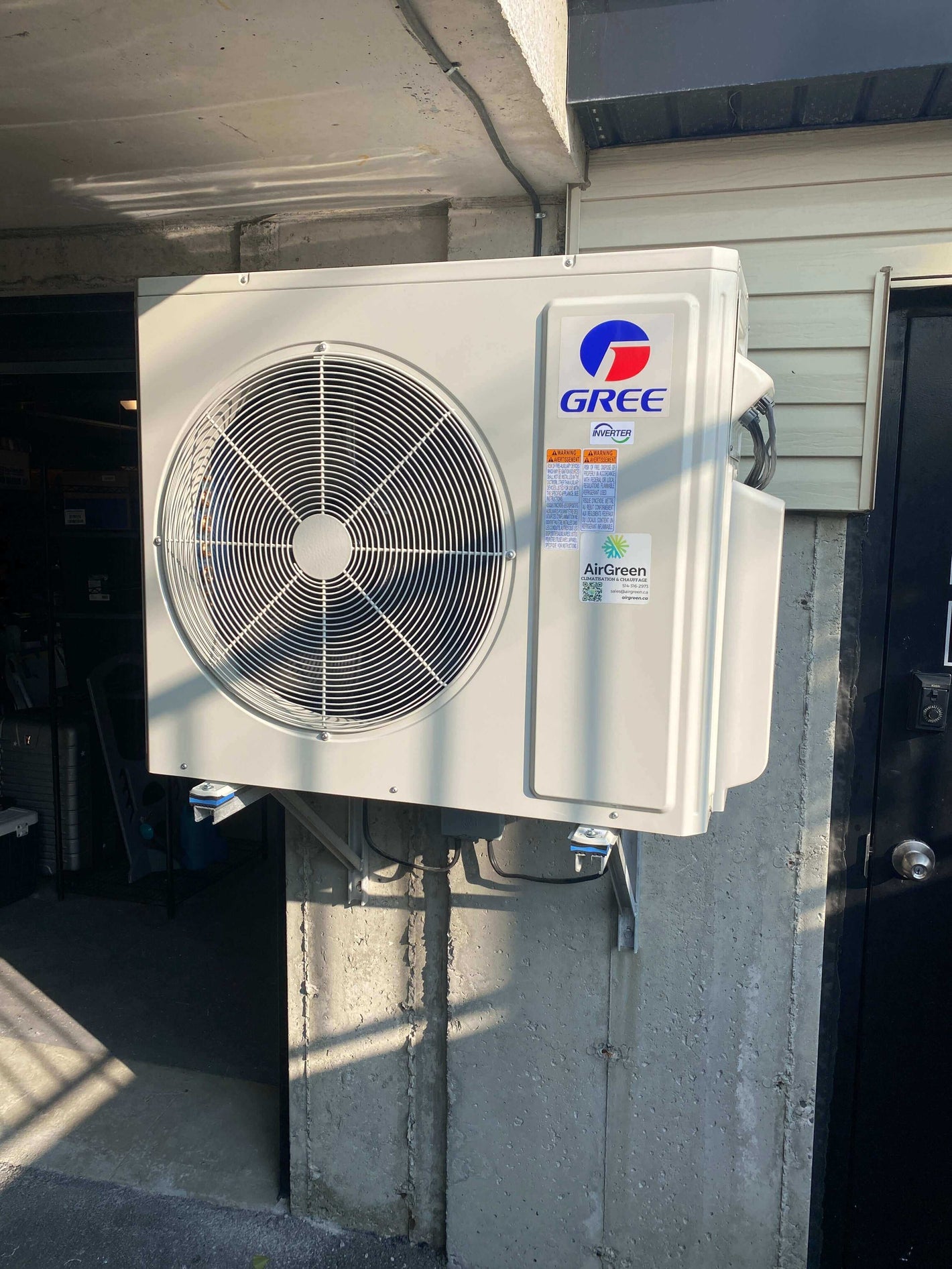 Outdoor Gree air conditioning unit mounted on a concrete wall, providing energy-efficient cooling solutions for residential spaces.