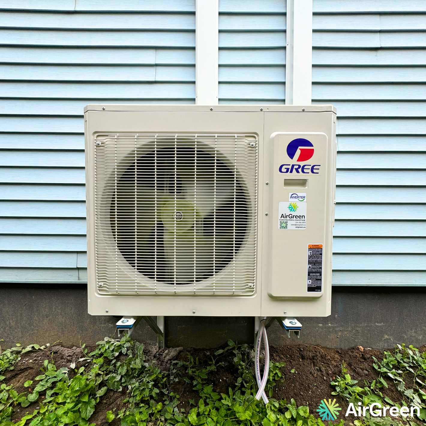 Gree air conditioning unit installed outside on a blue wall, energy-efficient cooling solution by AirGreen.