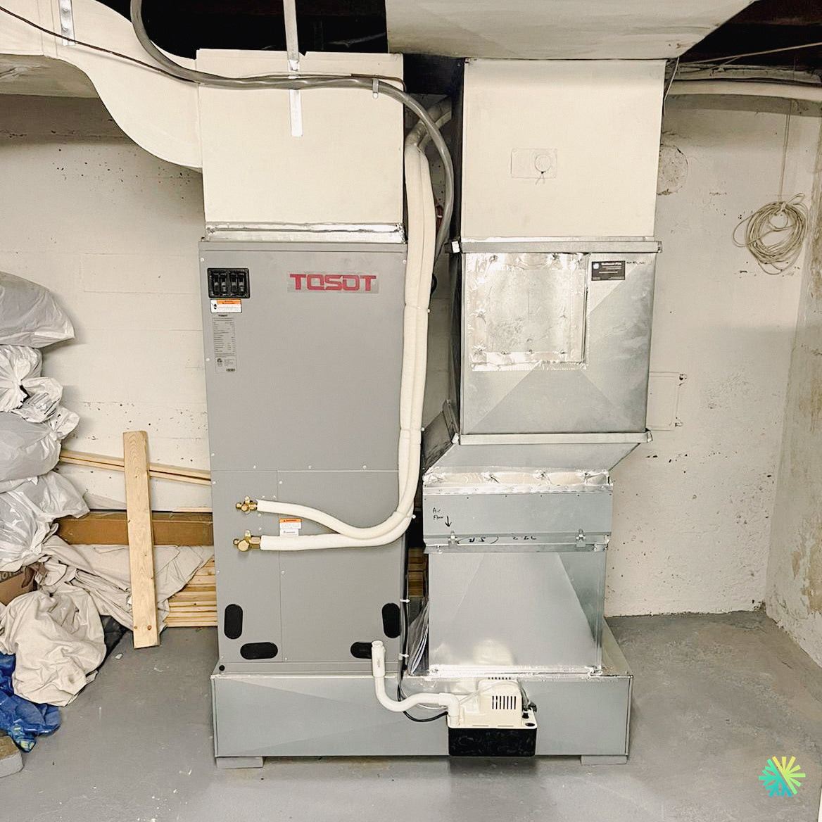 Tosot HVAC unit installed in a basement, featuring ductwork and piping, providing home heating and air conditioning system setup.