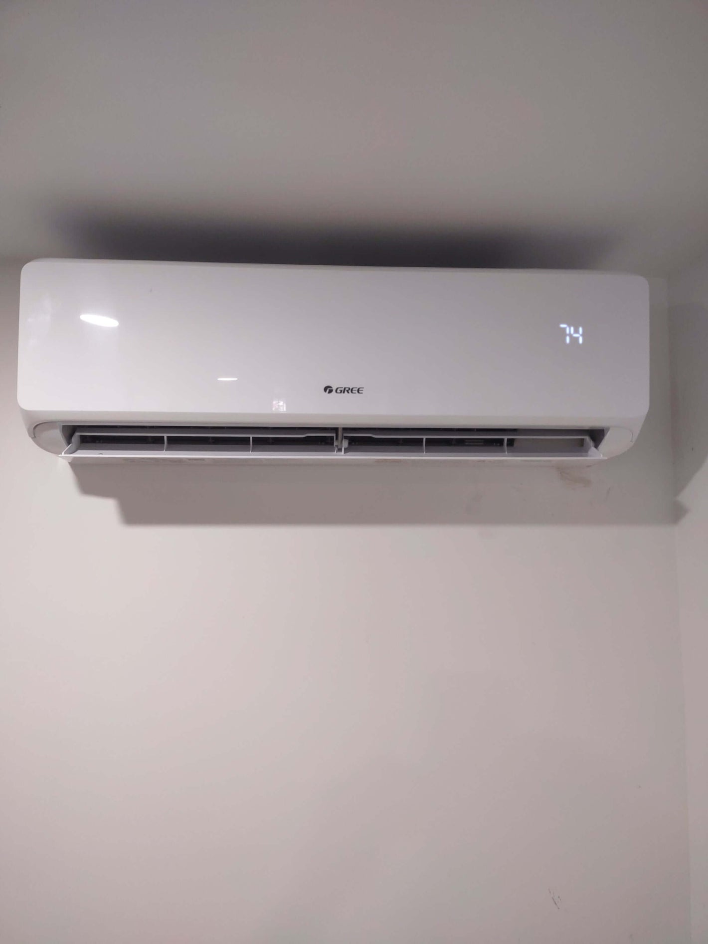 Gree wall-mounted air conditioner displaying temperature of 74 degrees.