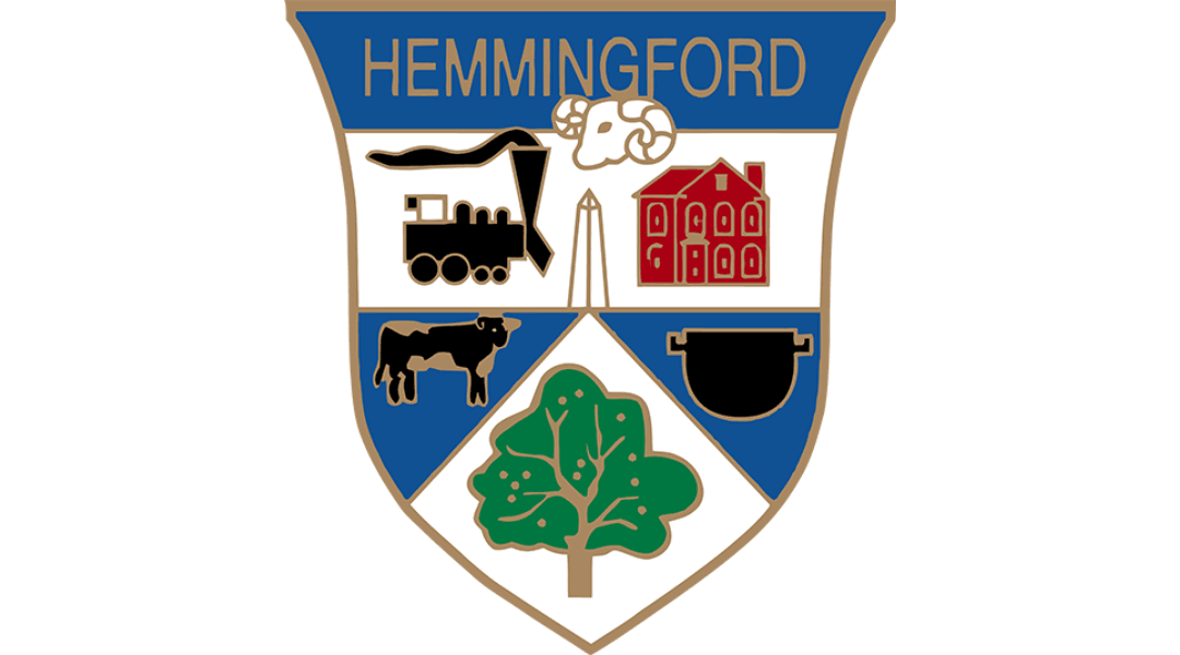 Hemmingford emblem with train, sheep, building, cow, tree, and cauldron symbols on a shield background.