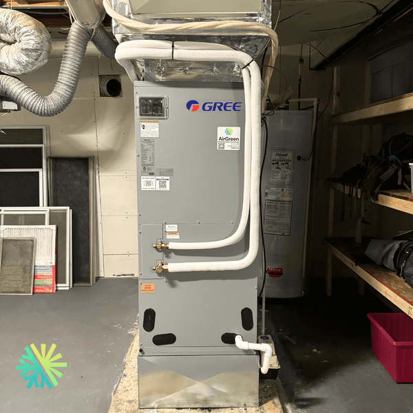 Gree HVAC system installed in a basement with pipes and a water heater in the background.