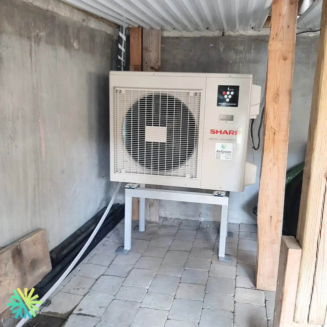 Sharp Eco Inverter heat pump installed in a basement for energy-efficient heating, featuring an external fan and control panel.