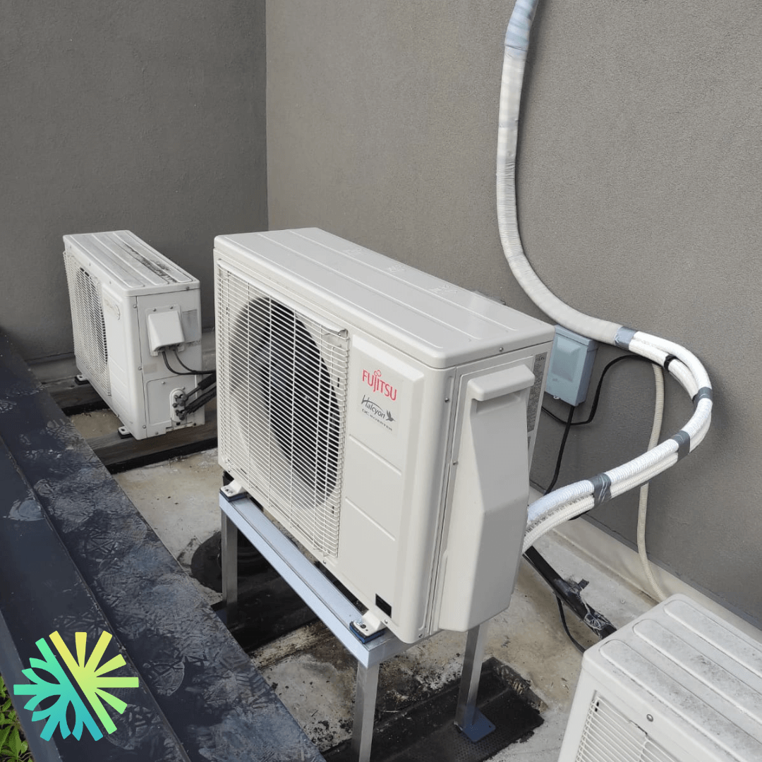 Outdoor Fujitsu air conditioning units installed on a rooftop with connected cabling for efficient cooling.