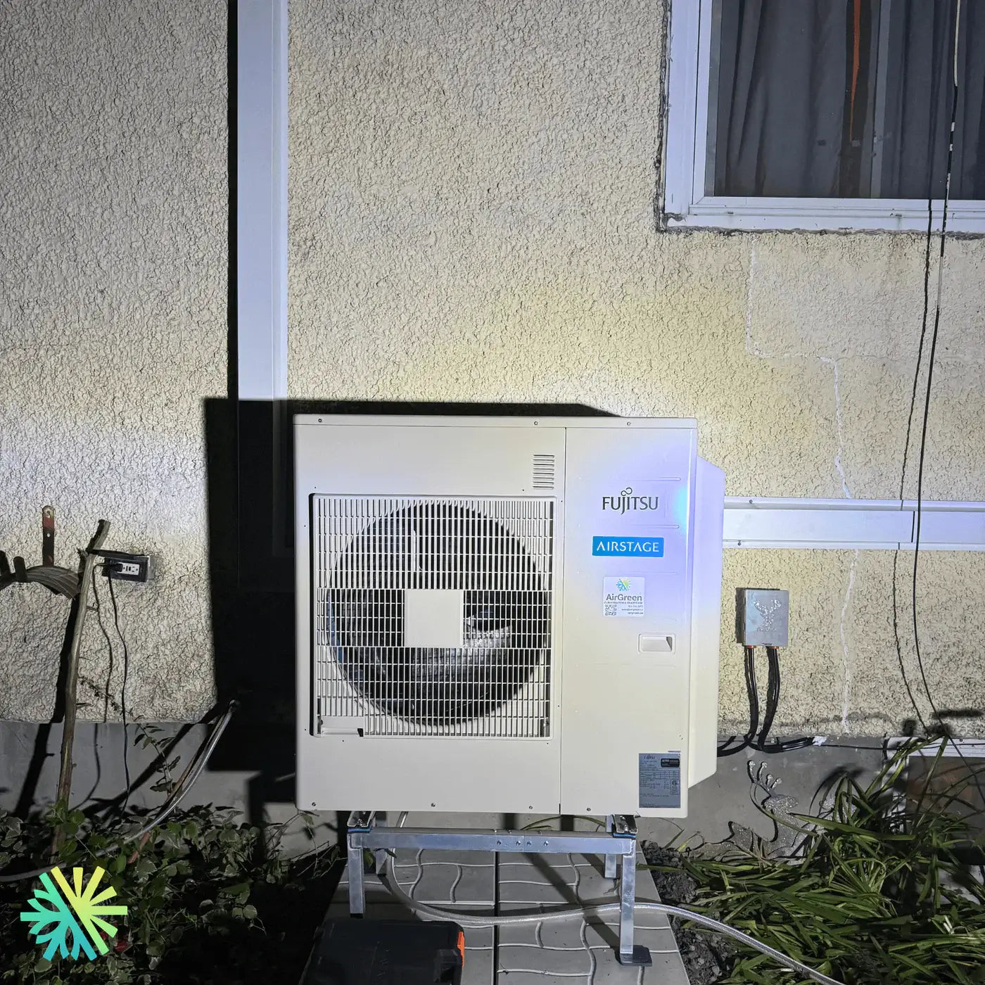 Fujitsu Airstage outdoor air conditioning unit installed on a residential wall